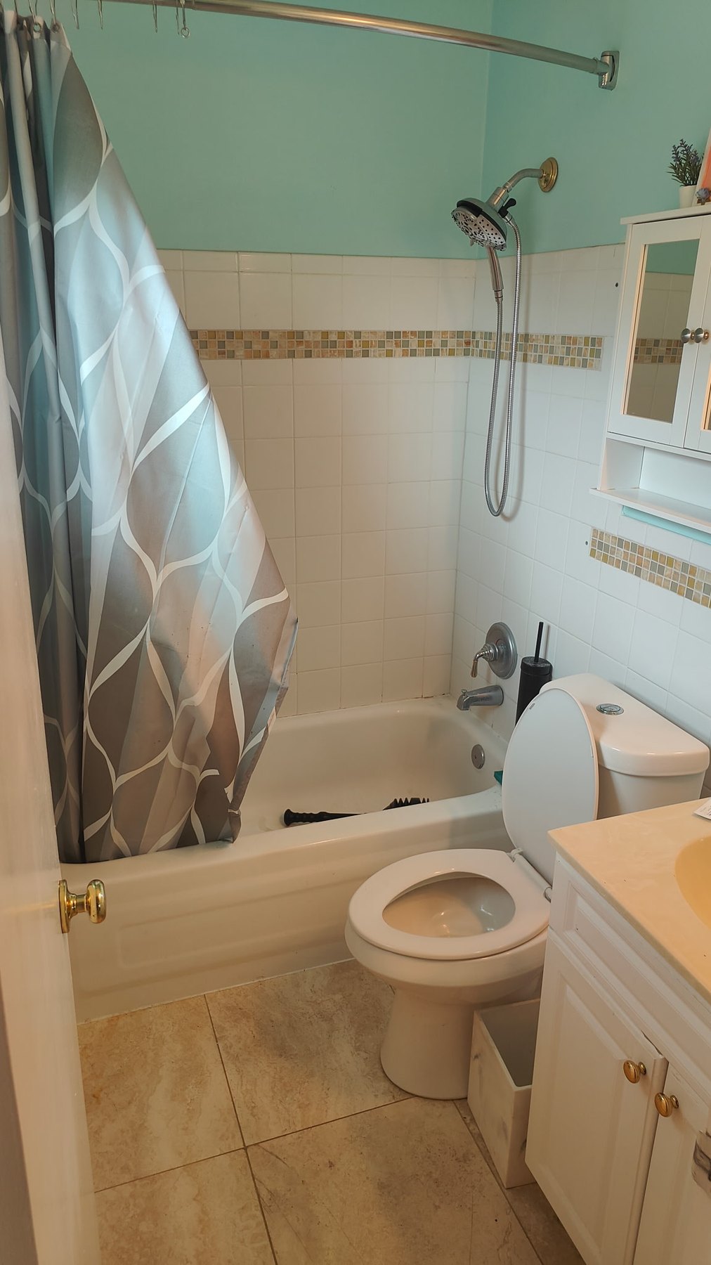 Bathroom before remodel with original tub and wall tile