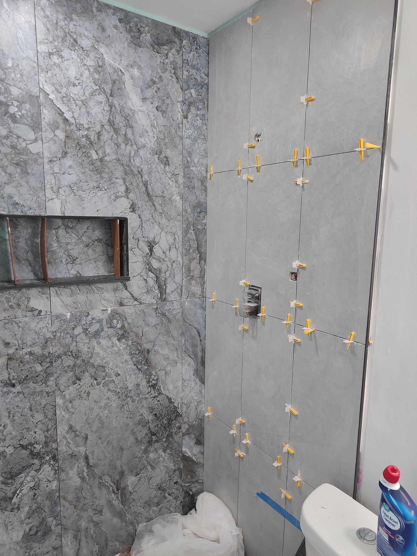 Large format bathroom shower tile installation in progress